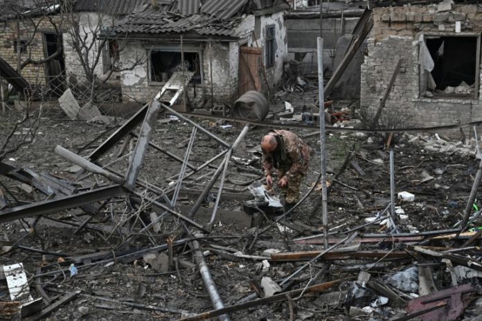 Un oficial de policía inspecciona los restos de un misil ruso que impactó en una zona residencial, en Zaporiyia,